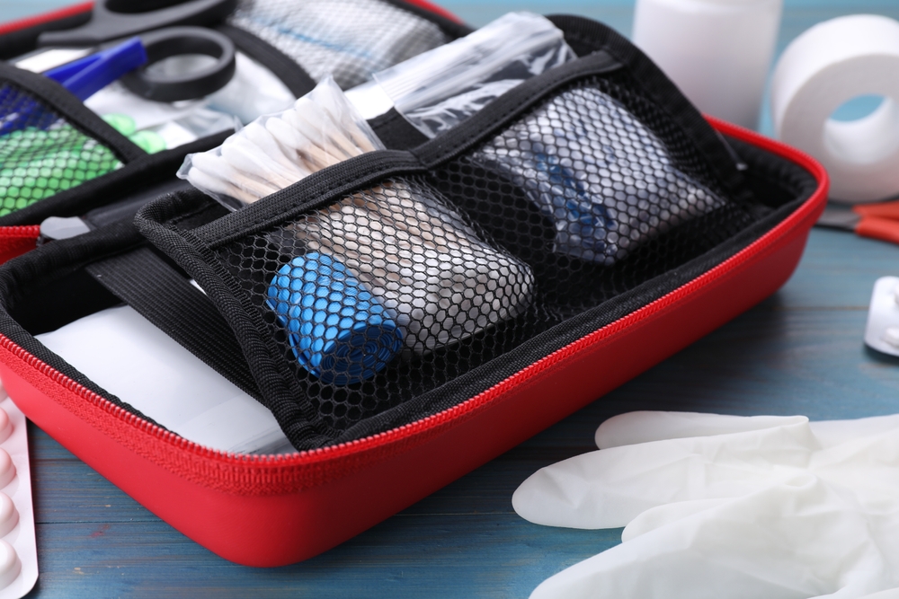 Close-up of a first aid kit on a blue wooden table for pet health and safety preparedness at home